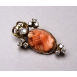 A late 19th century carved coral cameo pendant - set in yellow metal, possibly 9ct, with diamonds