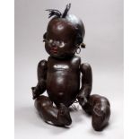 A 20th century black composition doll - with woollen top knot and sideburns, also including