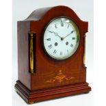 An early 20th century mahogany cased mantel clock - the arched case with brass pilasters and