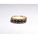 A 9ct yellow gold sapphire dress ring - graduated claw setting, size L/M, weight 2g.