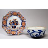 An Imari plate - the centre decorated with a vase of flowers, within a ribbed octagonal border,