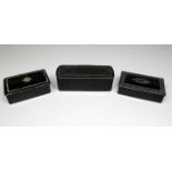 Three papier mache snuff boxes with inlaid lids - largest width 8.2cm.