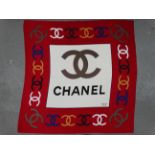 A Chanel silk scarf - the dark red border with CC logo in black, white, taupe, yellow and blue, 85 x