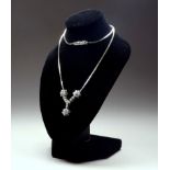 An 18ct white gold and diamond pendant necklace- arranged in floral clusters, weight 13.2g.
