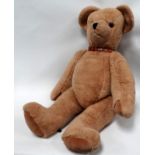 A large articulated teddy bear - with brown suede paws and brown leather studded collar with bell,