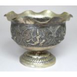 An oriental white metal pedestal bowl - with wavy rim and repousse decorated with deities, impressed