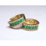 A pair of 14ct yellow gold emerald and diamond set ear stud - of hinged hoop form, pave set stones