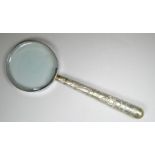 An oriental magnifying glass with white metal handle - decorated with figures in a landscape, length