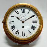 An early 20th century bulkhead timepiece - the circular brass case mounted on a mahogany disc, the