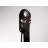 A late 19th/early 20th century African ebony staff - the contorted shaft terminating with a carved