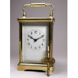 An early 20th century carriage clock - in a brass corniche case, the white enamel dial set out in