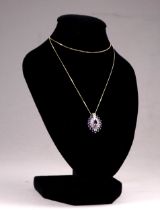 A 9ct yellow gold amethyst and diamond pendant - navette shaped and on a fine 9ct yellow gold chain,