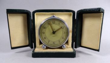 A mid 20th century Smiths travelling alarm clock - with circular chrome case and two tone dial set