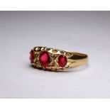 An 18ct yellow gold three stone garnet dress ring - with a pierced open setting, ring size P/Q,