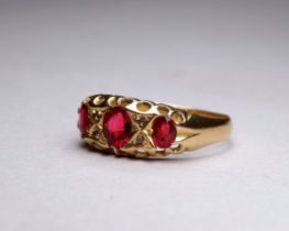 An 18ct yellow gold three stone garnet dress ring - with a pierced open setting, ring size P/Q,