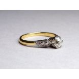 A solitaire diamond ring set in an 18ct yellow gold band - the claw set stone with diamond set