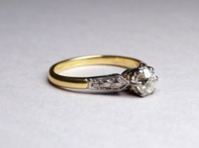 A solitaire diamond ring set in an 18ct yellow gold band - the claw set stone with diamond set