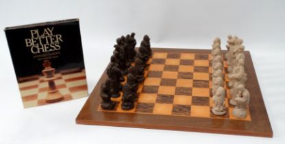 A late 20th century chess board and pieces - veneered in satin birch and palmwood, the resin cast