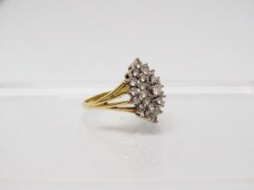 An 18ct gold diamond set twenty nine stone diamond cluster ring, the platinum claw set head of