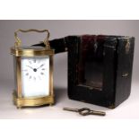 A 20th century carriage timepiece - with an ogee shaped case fitted with a white enamel dial set out
