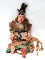 A 20th century Indonesian doll - with painted wooden head and hands the fabric body in traditional