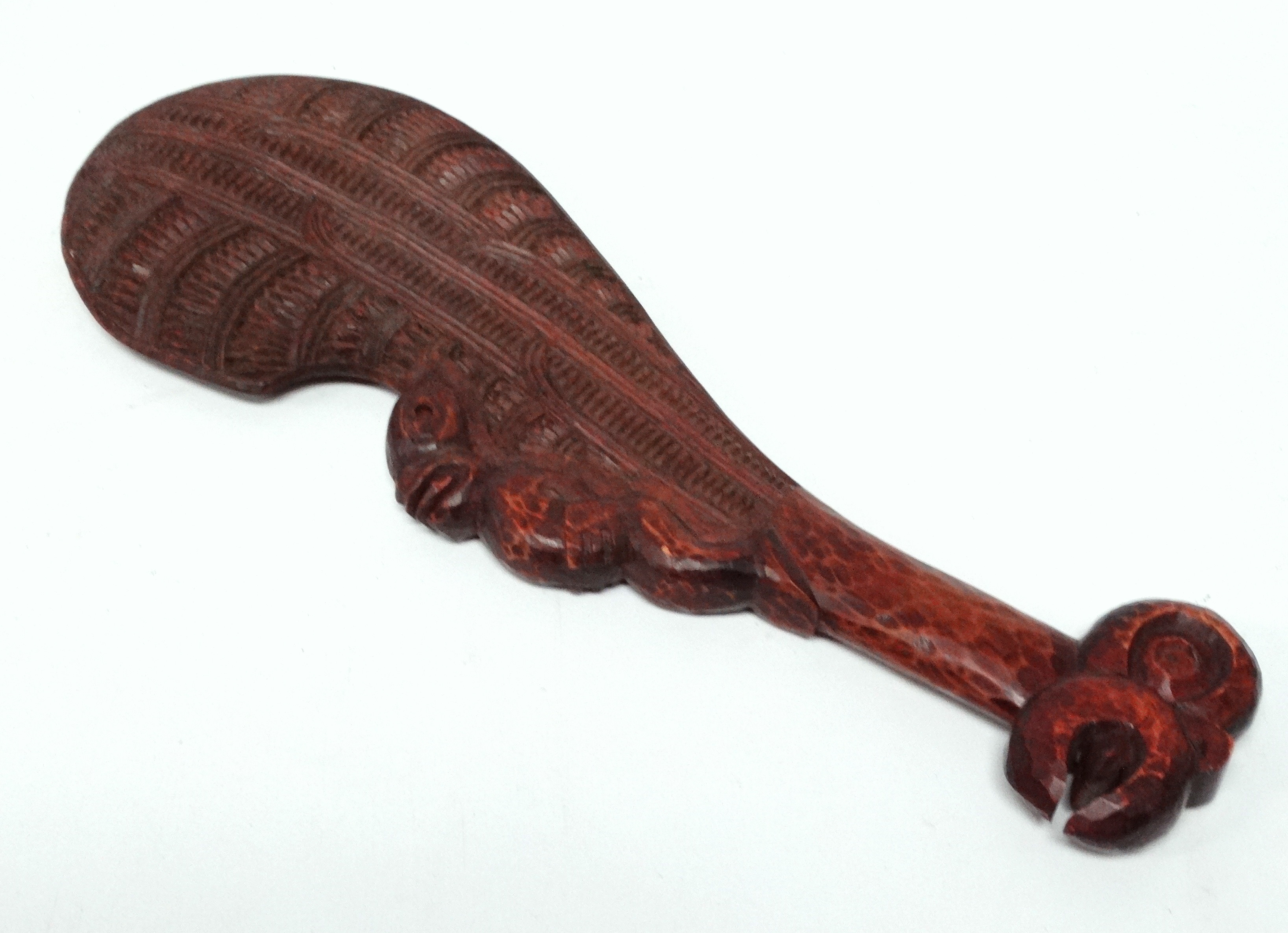 A Maori hand club wahaika - with linear and notched carving to the blade and with a tiki figure to