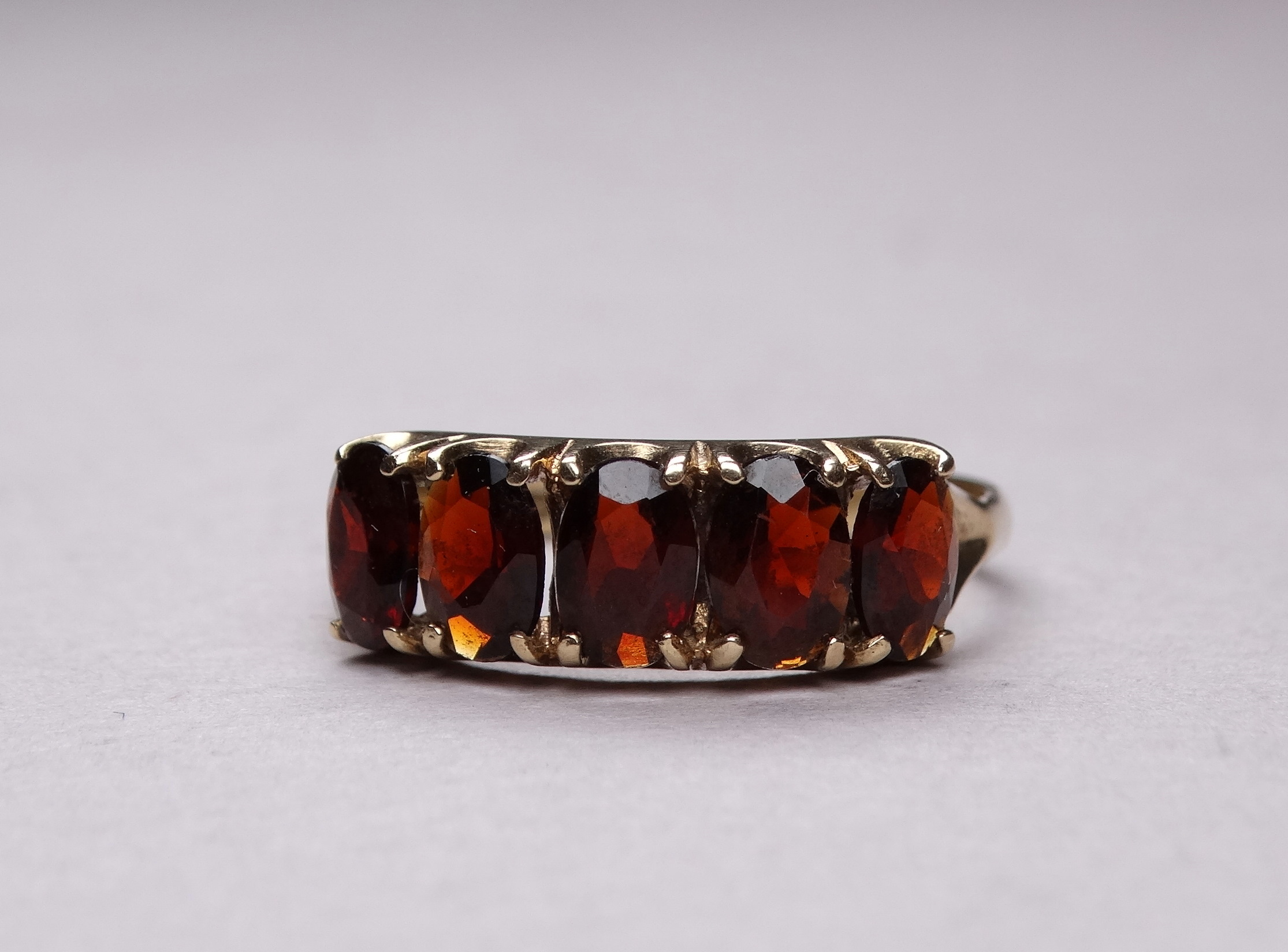 A 9ct yellow gold five stone garnet ring - claw set oval stones, ring size R-S, weight 2.6g. - Image 2 of 5