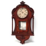 An early 20th century walnut cased American wall clock - the leaf carved case with glazed panel door