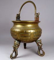 A late 19th century Chinese brass censer - of cauldron form with hoop handle and raised on three