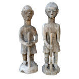 A pair of 19th century African carved hardwood figures of European hunters - each holding a rifle,