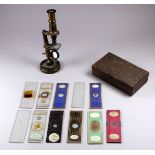 A late 19th/early 20th century pocket microscope - height 14cm, with a selection of slides (2).