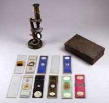 A late 19th/early 20th century pocket microscope - height 14cm, with a selection of slides (2).