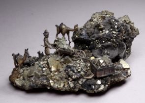 A small specimen of iron pyrite - surmounted with a small cast metal figure of a gold miner beside