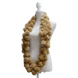 A light brown fur pom-pom scarf - in the form of a hoop.