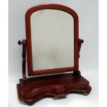 A Victorian mahogany toilet mirror - with an arched rectangular plate between shaped supports, on