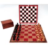 A late 19th/early 20th century Staunton chess set - the weighted pieces in boxwood and coloured