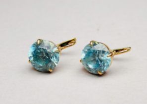 A pair of blue topaz earrings - the circular faceted stone set in yellow metal, possibly 9ct, weight
