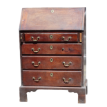 A George III red walnut bureau of small proportions - the cleated fall enclosing a fitted interior