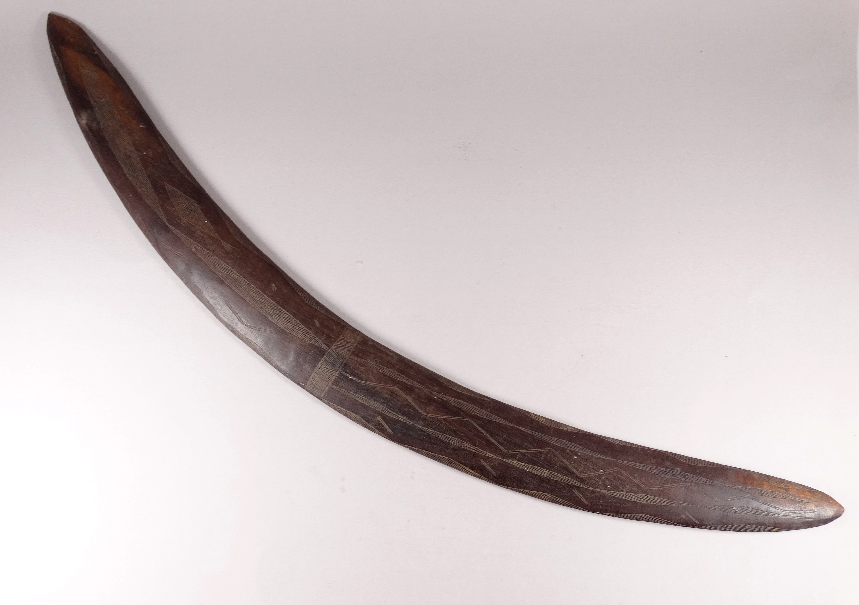 An early 20th century Australian hardwood boomerang - with linear incised panel decoration, length