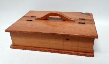 A 19th century two division pine cutlery box - with a central handle flanked by lidded compartments,