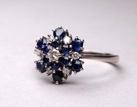 An 18ct white gold blue topaz and diamond set ring - the cluster setting in three steps, ring size