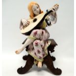 An early 20th century Arts & Crafts style pottery figure - modelled as a woman playing a lute,