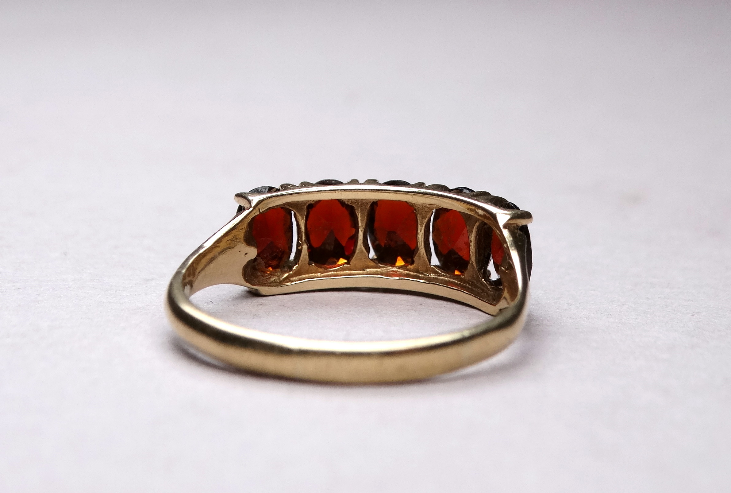 A 9ct yellow gold five stone garnet ring - claw set oval stones, ring size R-S, weight 2.6g. - Image 5 of 5