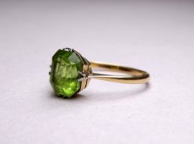 An 18ct yellow gold ring set with peridot - the emerald cut stone with a claw setting, ring size