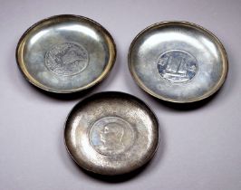 A 20th century Chinese white metal dish - incorporating a coin, together with another similar