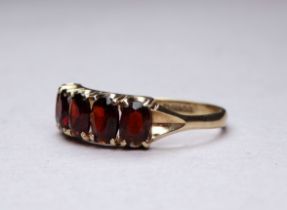 A 9ct yellow gold five stone garnet ring - claw set oval stones, ring size R-S, weight 2.6g.