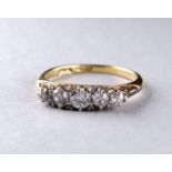 A five stone diamond ring - with a foliate scroll setting on an 18ct yellow gold band, ring size