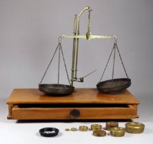 A pair of early 20th century brass balance scales - the rectangular walnut base fitted with a