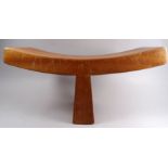 A 20th century walnut yoke shaped squatting stool - raised on a single tapering support, with an