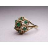 A 9ct yellow gold emerald cluster ring - with rope twist floral setting, ring size N, weight 4.2g.